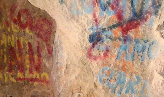 В Чили вандалы нанесли граффити поверх древних рисунков в пещере