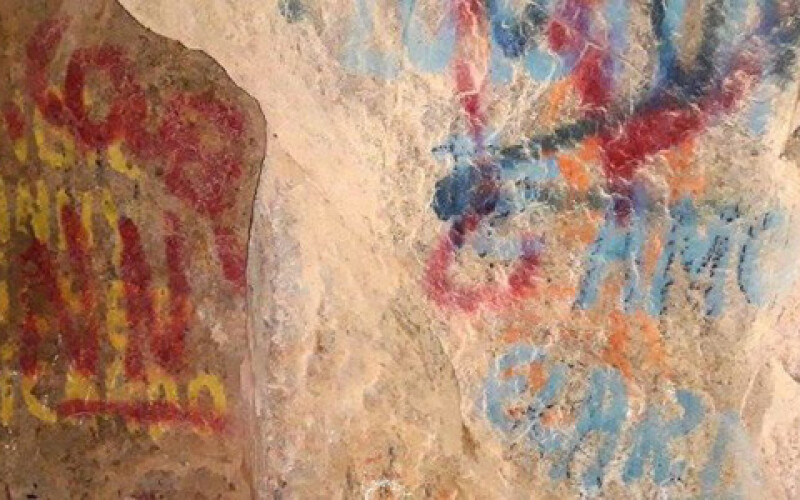 В Чили вандалы нанесли граффити поверх древних рисунков в пещере