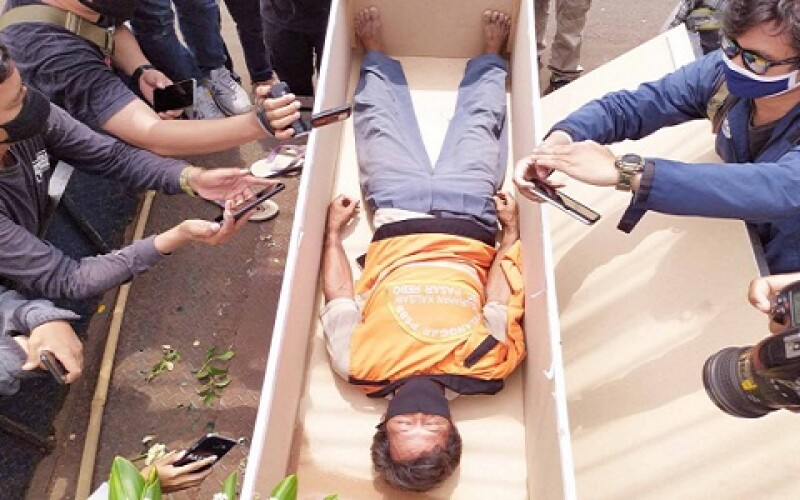 В Індонезії порушників карантину примушували лежати у трунах